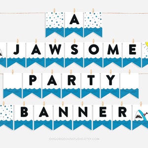 May include: A blue and white banner with the words "JAWSOME PARTY BANNER" in black letters. The banner features a shark, a sun, and blue waves.