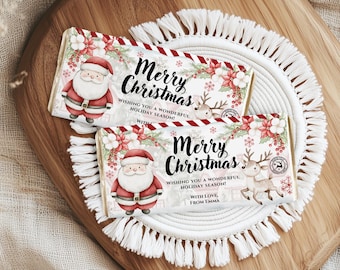 May include: Two white chocolate bar wrappers with a Christmas theme. The wrappers feature a red and white striped border, a watercolor illustration of Santa Claus, a reindeer, and poinsettias. The text on the wrappers reads "Merry Christmas" and "Wishing you a wonderful holiday season!" One wrapper also includes the text "With love, from Emma."