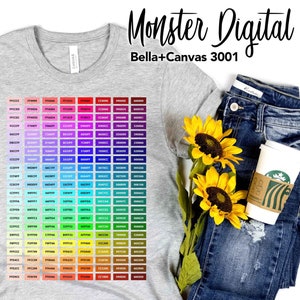 May include: A gray Bella + Canvas 3001 t-shirt with a rainbow color chart printed on the front. The chart shows a variety of colors in a grid format. The t-shirt is displayed on a white background with a pair of blue jeans and sunflowers.