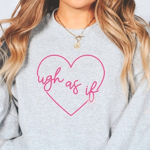 May include: Grey sweatshirt with a pink heart and the text "ugh as if" inside the heart.