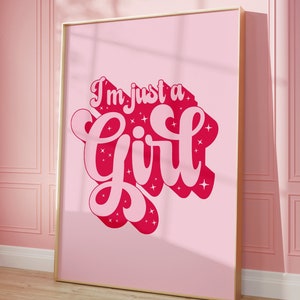 K&ouml;nnte beinhalten: Ein rosa gerahmtes Poster mit dem Text "I'm just a girl" in einer rosa und roten Schriftart mit Glitzerakzenten.
