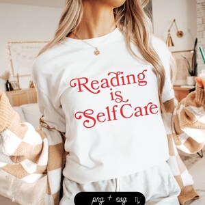 Puede incluir: Camiseta blanca con texto rojo que dice "Reading is Self Care".