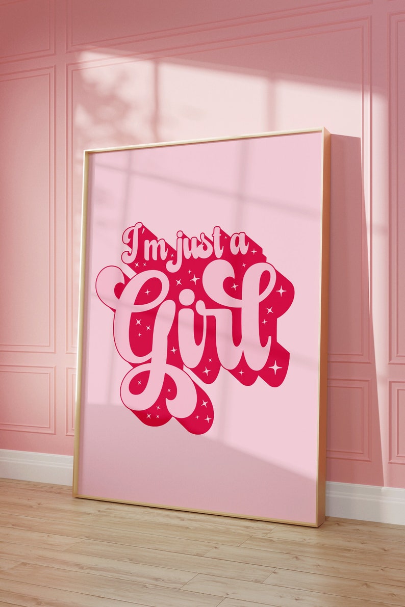 K&ouml;nnte beinhalten: Ein rosa gerahmtes Poster mit dem Text "I'm just a girl" in einer rosa und roten Schriftart mit Glitzerakzenten.