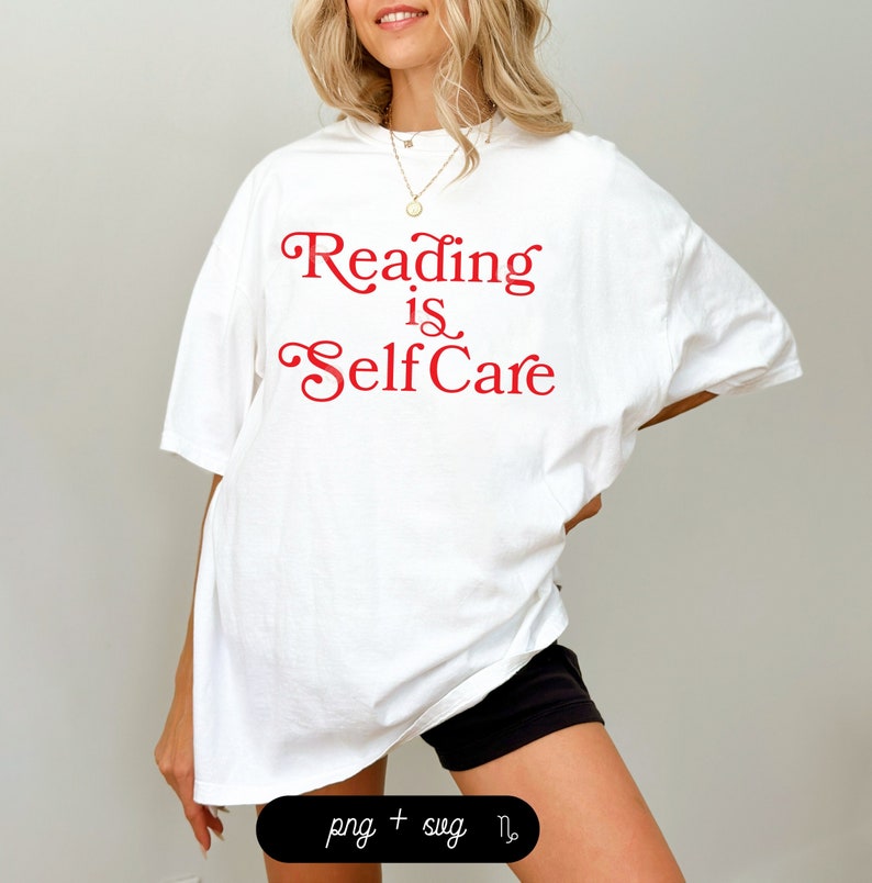 Puede incluir: Camiseta blanca de gran tama&ntilde;o con el texto "Reading is Self Care" en letras rojas.