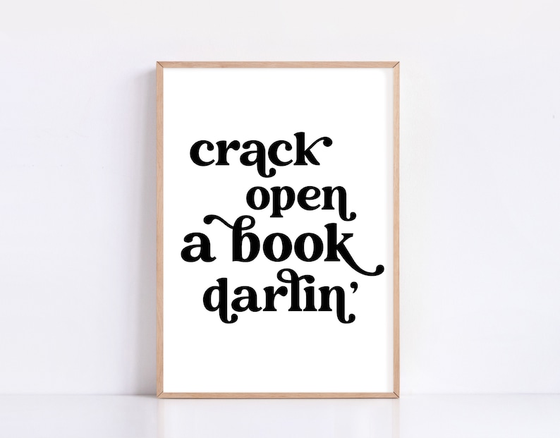 May include: A black and white printable wall art print with the text "crack open a book darlin'" in a retro font style.