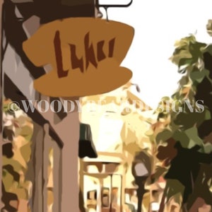 May include: A yellow sign with the word "Luki" on it hangs above a street in a city. The sign is attached to a building with a brown facade. The street is lined with buildings and trees.
