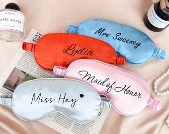Puede incluir: Cuatro máscaras de dormir de satén con diferentes nombres y títulos bordados. Las máscaras son de color azul, rosa, rojo y azul claro. El texto en las máscaras dice: "Mrs. Sweeney", "Lydia", "Dama de honor" y "Miss Hay".