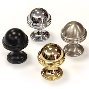 May include: Four decorative cabinet knobs in different finishes: black, chrome, brushed nickel, and gold. Each knob features a spherical top with a ridged base, offering a classic design for furniture or cabinetry.