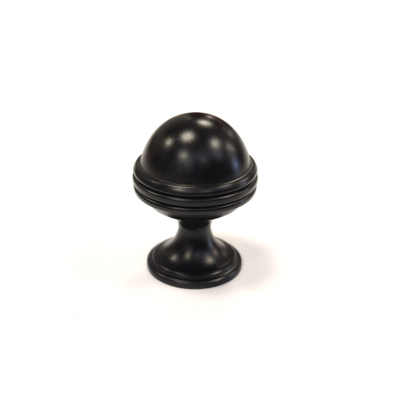 May include: A black cabinet knob with a spherical top and a decorative base. The knob has a matte finish and is designed for furniture. The spherical top has a series of horizontal grooves. The base is round and slightly flared.