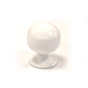 May include: A white, spherical cabinet knob with a glossy finish. The knob sits atop a short, rounded stem and a circular base. The design is simple and modern, suitable for various furniture styles. The knob is made of ceramic or porcelain.