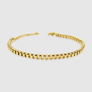 May include: A gold chain bracelet with a square link design.