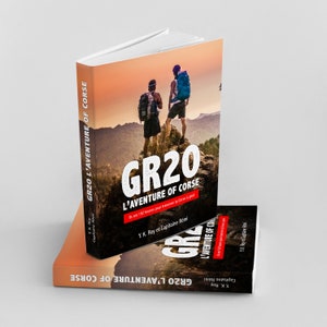 May include: Two hikers stand on a mountaintop with backpacks, looking out at a scenic view. The cover of a book titled "GR20 L'AVENTURE OF CORSE" is visible. The book cover features a red and white text design and a sunset background.