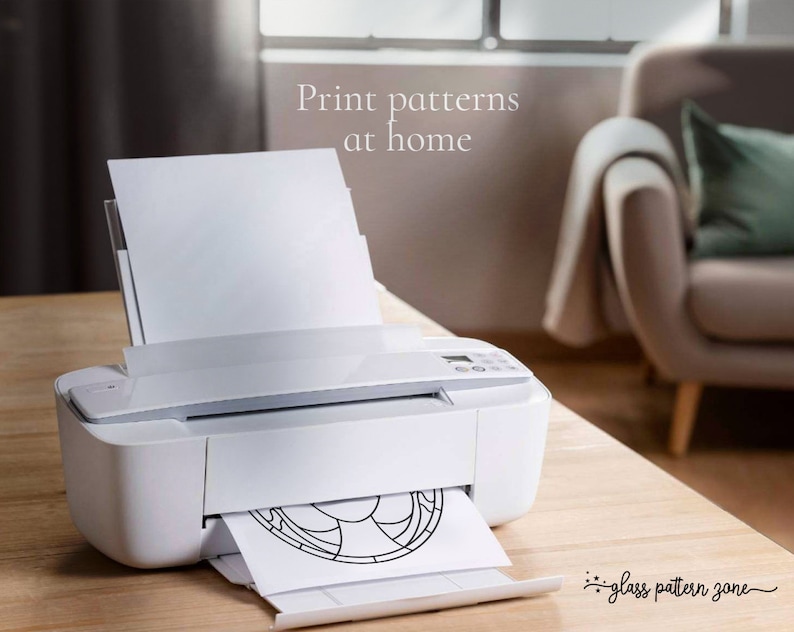 K&ouml;nnte beinhalten: Ein wei&szlig;er Drucker mit einem Blatt Papier, das durch ihn gef&uuml;hrt wird. Das Papier hat ein schwarz-wei&szlig;es Glasmalereimuster darauf gedruckt. Der Text "Drucken Sie Muster zu Hause" ist &uuml;ber dem Drucker sichtbar. Der Text "Glasmusterzone" ist unter dem Drucker sichtbar.