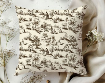 May include: A cream-colored throw pillow with a brown and white toile pattern featuring a repeating design of houses, trees, and figures.