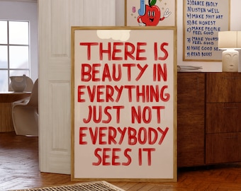 Pode incluir: Um poster de parede retangular emoldurado com o texto vermelho "THERE IS BEAUTY IN EVERYTHING JUST NOT EVERYBODY SEES IT" num estilo de pincel desenhado à mão sobre um fundo creme claro, apresentado numa moldura de madeira clara simples.