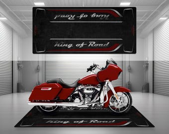Puede incluir: Una motocicleta roja con una alfombra de suelo negra y plateada que dice "King of Road" en una fuente estilizada. La motocicleta está en un garaje.