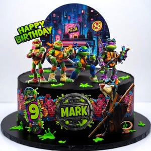 May include: A black birthday cake decorated with Teenage Mutant Ninja Turtles figurines, a cityscape backdrop, and the words "Happy Birthday." The cake also features a skateboard with the number 9 and the name "Mark."
