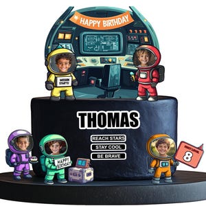 May include: A black and blue space-themed birthday cake with a spaceship and astronaut figurines. The cake is decorated with the name "THOMAS" and the words "REACH STARS", "STAY COOL", and "BE BRAVE". The cake also has a number 8 on it.