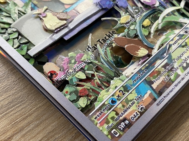 May include: A Pokemon trading card with a blue and white background. The card features a brown and yellow Pokemon with a green, blue, and purple background. The card has the text 'This Pokemon', 'Tackle', 'Weakness', 'Resistance', 'Retreat', 'Illus. MINAMINAMI Toke', 'GSVP 044', 'From the time it is born, a Iron-Mime Jr. would eat its tail. Its life would end.', and '02023 Pokemon/Nintendo/Creatures Inc.'