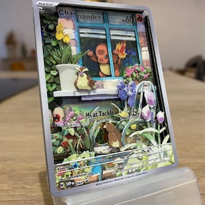 May include: A Pokemon trading card featuring Charmander, a fire-type Pokemon. The card is a 3D pop-up style with a detailed background of a window with flowers and plants. The card has a light blue background with the text 'BASIC' in the top left corner. The card has the text 'Charmander' in the top center. The card has the text '60' in the top right corner. The card has the text 'Hat Tackle' in the center. The card has the text 'This Pokemon can't be damaged by attacks that make it go to sleep.' in the center. The card has the text 'Weakness: Water x2' in the bottom left corner. The card has the text 'Resistance: None' in the bottom center. The card has the text 'Retreat: 1' in the bottom right corner. The card has the text 'From the moment it is born, a flame burns at the tip of its tail. It is said that the flame will go out if the Charmander's life force is ever to go out.' in the bottom center. The card has the text 'Illus. MINAMINAMI Toke' in the bottom left corner. The card has the text '©2023 Pokemon/Nintendo/Creatures/GAME FREAK' in the bottom right corner. The card has the text '6 SVP 044' in the bottom left corner.