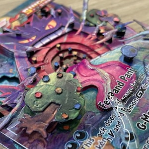 May include: A close-up of a G-Max Swallow Pokemon card with a 3D pop-up effect. The card features a purple and red Gengar with a pink and white swirl behind it. The card text reads 'Feraand Pani' and 'This attack does 30 damage for each of your opponent's Pokemon-GX in play. G-Max Swallow: During your next turn, this Pokemon can't attack.'