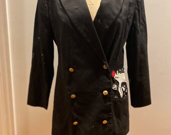 May include: A black double-breasted blazer with gold buttons and a sequined and embroidered patch on the pocket. The label reads "Wolf Form Co. N.Y.C."