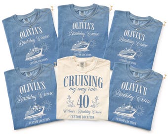 May include: A collection of blue and cream-colored t-shirts with cruise-themed graphics. The blue shirts read "Olivia's Birthday Cruise" with a ship illustration. The cream shirt says "Cruising my way into 40".