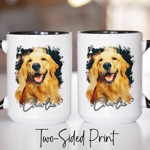 May include: Two white ceramic mugs with black rims and handles. Each mug features a smiling golden retriever portrait with the name "Charlie" in cursive. The mugs are labeled "Two-Sided Print".