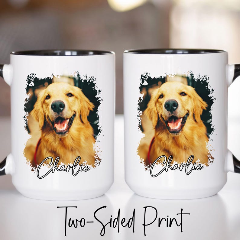 May include: Two white ceramic mugs with black rims and handles. Each mug features a smiling golden retriever portrait with the name "Charlie" in cursive. The mugs are labeled "Two-Sided Print".