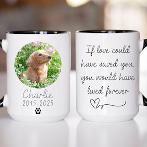 May include: White ceramic coffee mug with a black rim and handle. The mug has a photo of a dachshund in a field of flowers and the text "Charlie 2015-2025". The other side of the mug has the text "If love could have saved you, you would have lived forever".