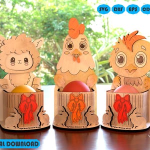 May include: Three wooden Easter egg holders, each featuring a different animal: a lamb, a chicken, and a chick. The holders are painted in natural wood tones and have a small, square opening for holding an egg. Each holder has a red bow and the word 