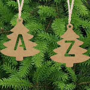 May include: Two brown paper Christmas tree ornaments with twine hangers. The ornaments are decorated with the letters A and Z.