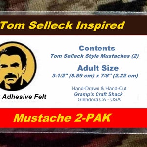 Puede incluir: Un paquete de plástico transparente que contiene dos bigotes de fieltro adhesivo negro. El paquete presenta una etiqueta con el texto "Tom Selleck Inspired" y una imagen de Tom Selleck. Los bigotes son de tamaño adulto, midiendo 8,89 cm x 2,22 cm.