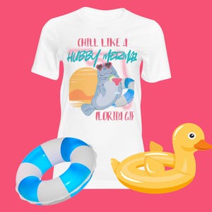 May include: White t-shirt with a graphic of a manatee wearing sunglasses and holding a cocktail, with the text "CHILL LIKE A HUBBY MERMAID FLORIDA GIF". Includes a blue and white striped inflatable ring and a yellow duck float.