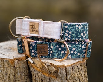 May include: Two dog collars with floral patterns. The top collar is white with a brown leather tag that says "Lola Grace". The bottom collar is dark blue with a white floral pattern and a brown leather tag that says "Lola Grace". Both collars have rose gold hardware.