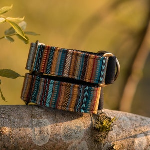 May include: Two colorful dog collars with a geometric pattern in shades of blue, brown, red, and white. The collars are made of fabric and have a metal D-ring.