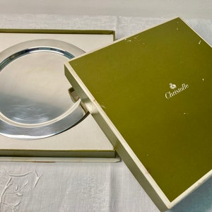 Peut inclure: Un plat de service en argent dans une boîte verte et blanche avec le nom de la marque "Christofle" imprimé sur la boîte.
