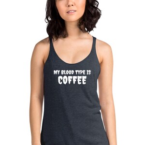 May include: Dark grey vest top with the white text "MY BLOOD TYPE IS COFFEE". The top has a scoop neck and thin straps. The material appears soft and comfortable. The text is in a bold, blocky font.