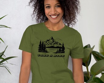 May include: A green short-sleeved t-shirt with a black mountain scene and the text "TAKE A HIKE" printed on the front.