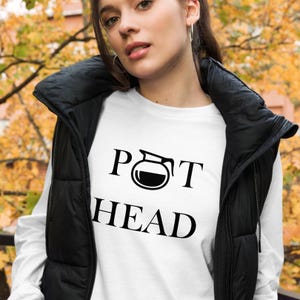 May include: White long-sleeve shirt with a black graphic of a coffee pot and the text "POT HEAD".