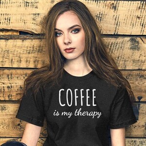 May include: A black t-shirt with white text that reads "COFFEE is my therapy".