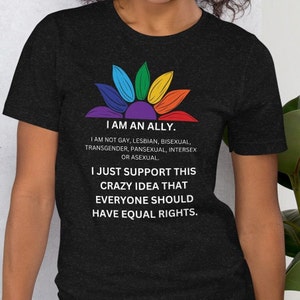 May include: A black t-shirt with a rainbow flower design and the text "I am an ally. I am not gay, lesbian, bisexual, transgender, pansexual, intersex or asexual. I just support this crazy idea that everyone should have equal rights."