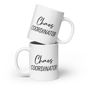 May include: Two white ceramic mugs stacked on top of each other. Both mugs have black text that reads "Chaos Coordinator".