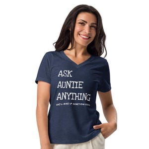 May include: A navy blue V-neck t-shirt with the text "ASK AUNTIE ANYTHING SHE'LL MAKE UP SOMETHING GOOD" in white. The shirt is made of a soft material.