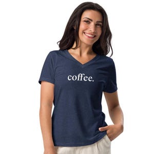 以下が含まれることがあります： 前面に白い文字で「coffee.」がプリントされたネイビーのVネックTシャツです。