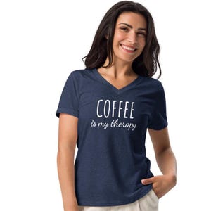 以下が含まれることがあります： 白文字で「COFFEE is my therapy」と書かれたネイビーブルーのVネックTシャツ。柔らかい素材で作られています。カジュアルウェアです。