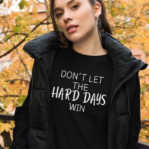 May include: A black t-shirt with white text that reads "Don't let the hard days win".