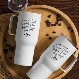 Könnte beinhalten: Zwei weiße Reisebecher mit schwarzem Text und Herzen. Der Text auf den Bechern lautet "Es tut mir leid für das, was ich gesagt habe, bevor ich meinen Kaffee hatte".