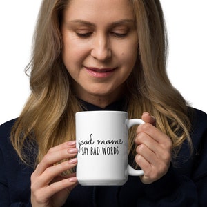May include: White ceramic coffee mug with black text that reads "good moms say bad words".