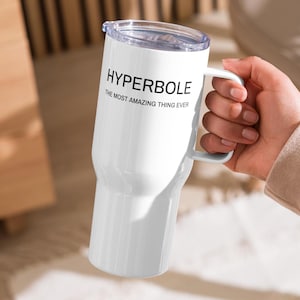 Puede incluir: Taza de viaje blanca con asa negra y una inscripción negra que dice "HYPERBOLE THE MOST AMAZING THING EVER".